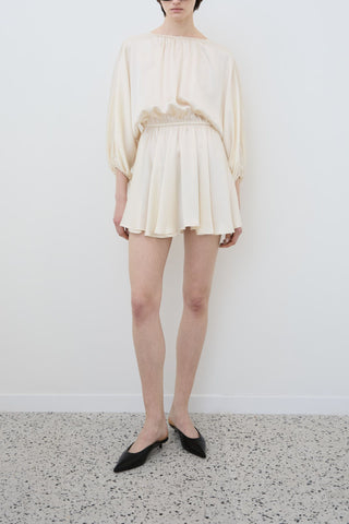 Front view of Ema mini dress in almond organic silk by HERTH, sustainable Italian womenswear available at ASSOLUTO boutique.