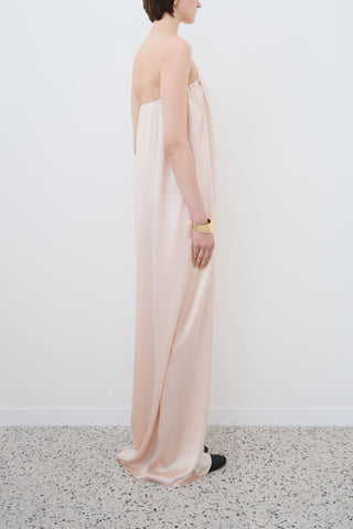 Side view of HERTH Erin off-shoulder maxi dress in organic silk — elegant sustainable womenswear made in Italy available at Assoluto Boutique.